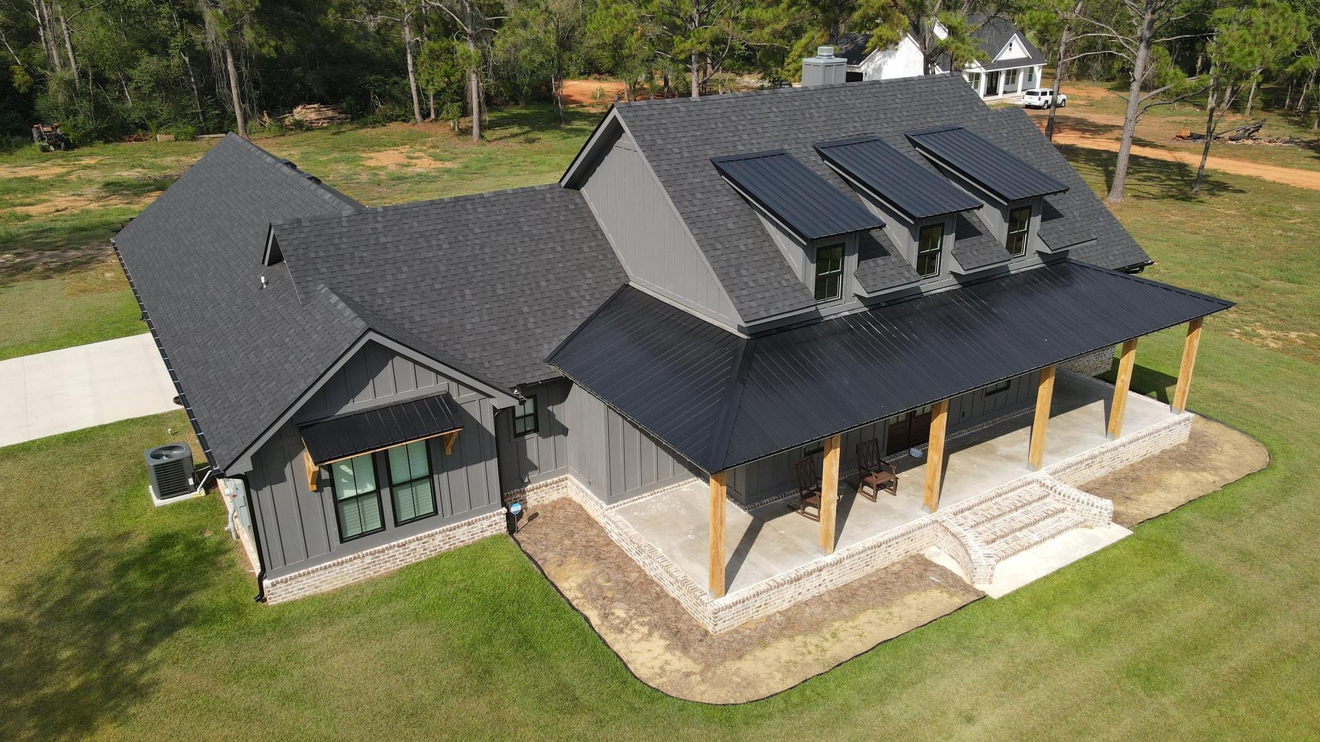 New dark shingle roof with metal porch roof on a home in Pensacola, FL